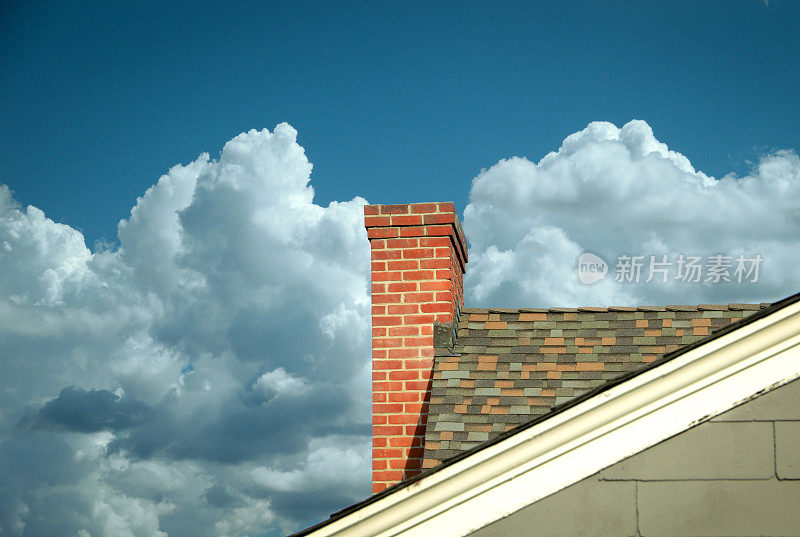 部分瓦屋顶与砖烟囱映衬在云中