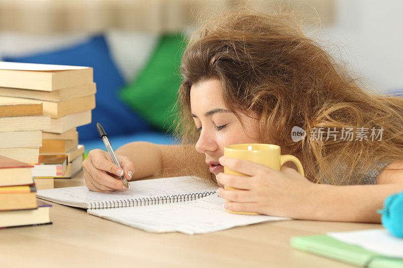疲倦和困倦的学生试图写笔记