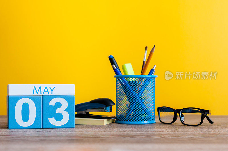 5月3日。月3日，日历放在商务办公室桌子上，工作地点在黄色背景。春天的时间