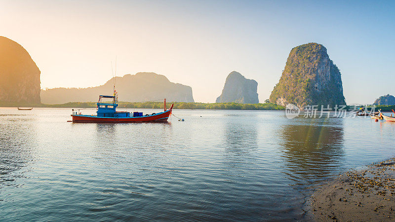 美丽的日落在热带海洋与长尾船在泰国南部