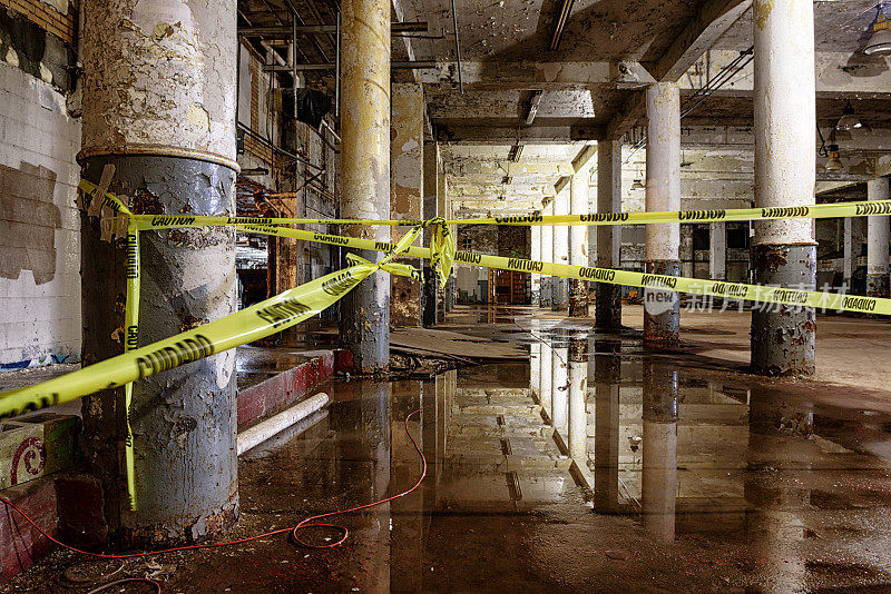 废弃的工业大楼，潮湿的地板，小心胶带
