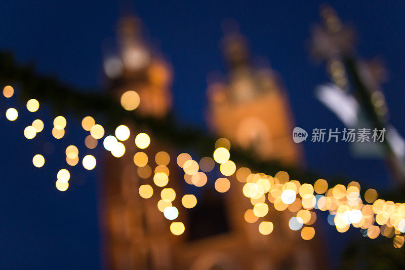 克拉科夫圣诞市场的散焦圣诞灯，背景是圣玛丽教堂
