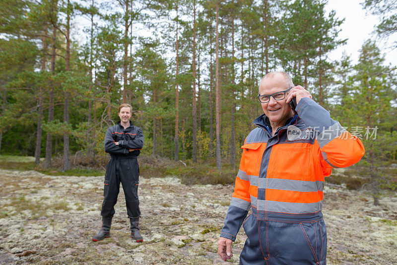 一个成熟的男人和一个年轻的男人一起在森林里工作