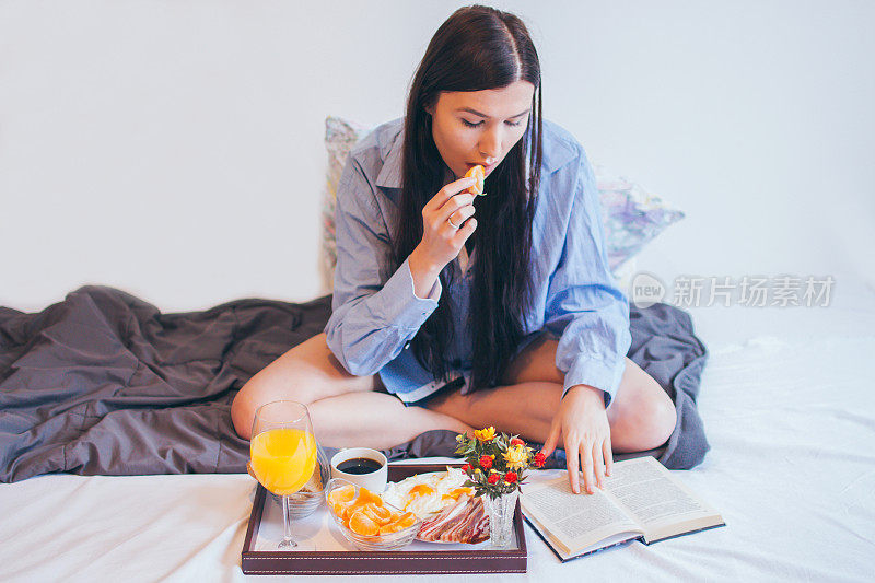 在床上吃早餐，读最喜欢的书的女人。