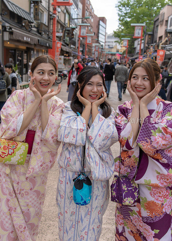 年轻的亚洲女性在传统的日本街道上做鬼脸