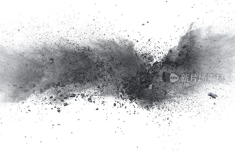 黑火药爆炸。木炭的颗粒飞溅在白色的背景上。特写的黑色尘埃颗粒飞溅孤立的背景。