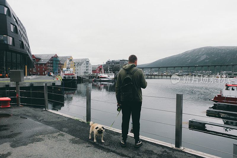 挪威特罗姆瑟，一个人和一只狗在散步