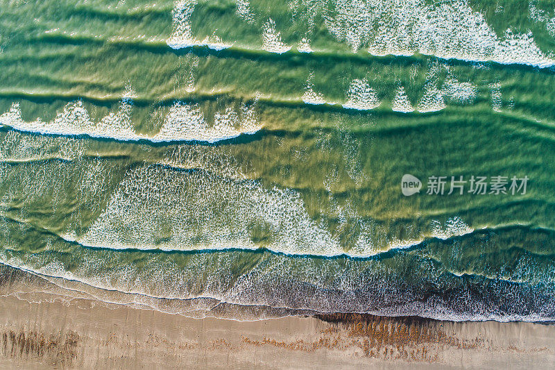 海浪拍打海滩的鸟瞰图。