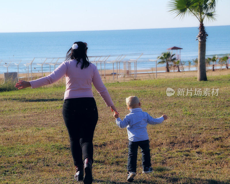 妈妈和儿子跑向海滩