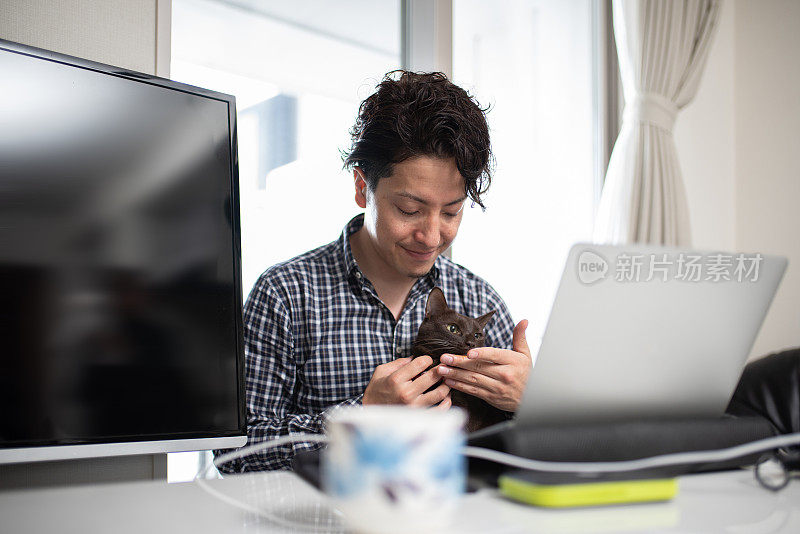 带着宠物在家工作的男人