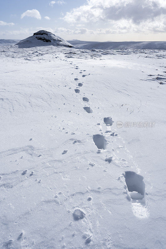 厚厚的雪地上的脚印通向达特穆尔的高威尔海斯