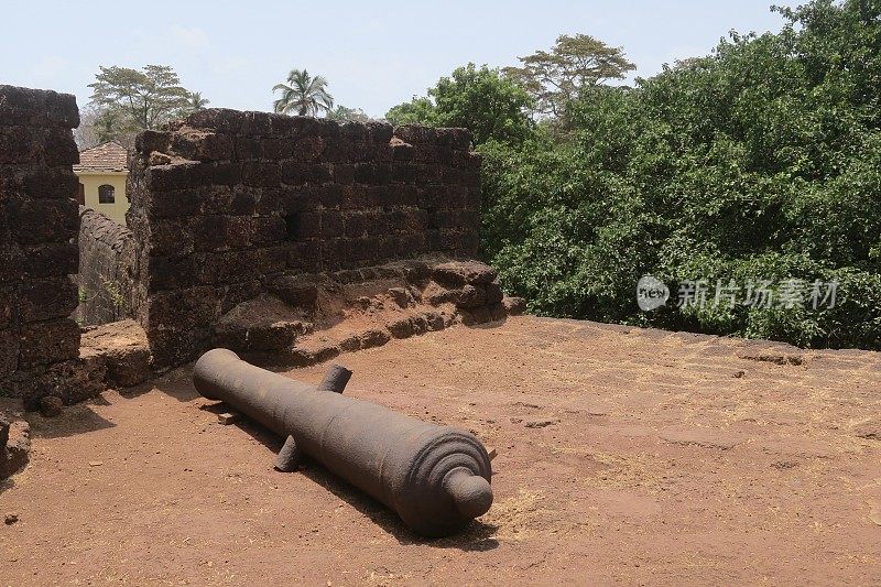 印度果阿，一门锈迹斑斑的铁炮被遗弃在加固墙旁的地上