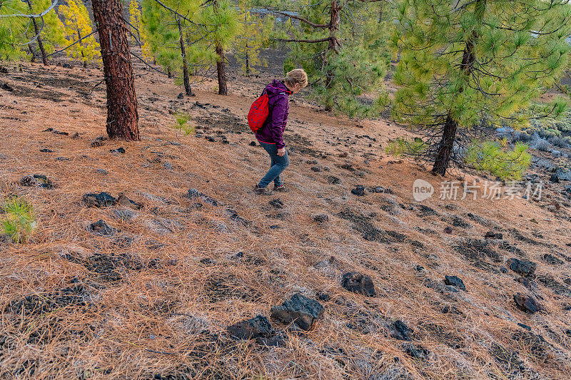 西班牙特内里费，一个成熟的女人在拍摄埃尔・特多火山下的一条道路