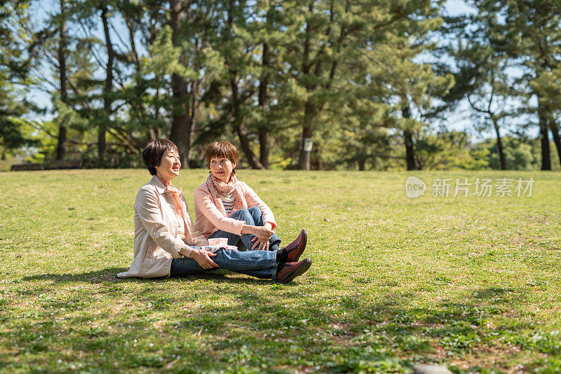 老母亲和女儿在草地上聊天
