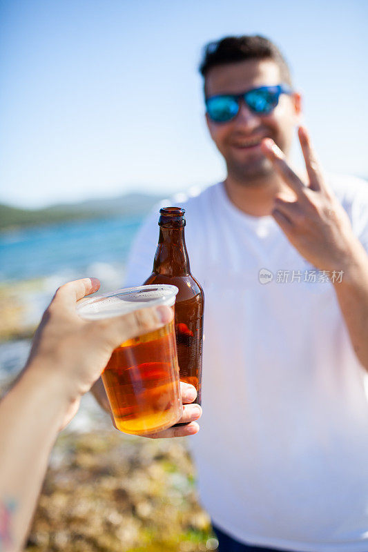 朋友们在海滩上喝啤酒