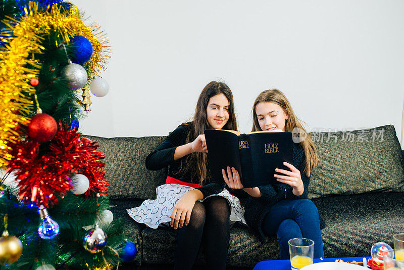 两个女孩在家里读圣经