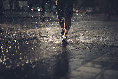 一个在雨中奔跑的不可辨认的男人。