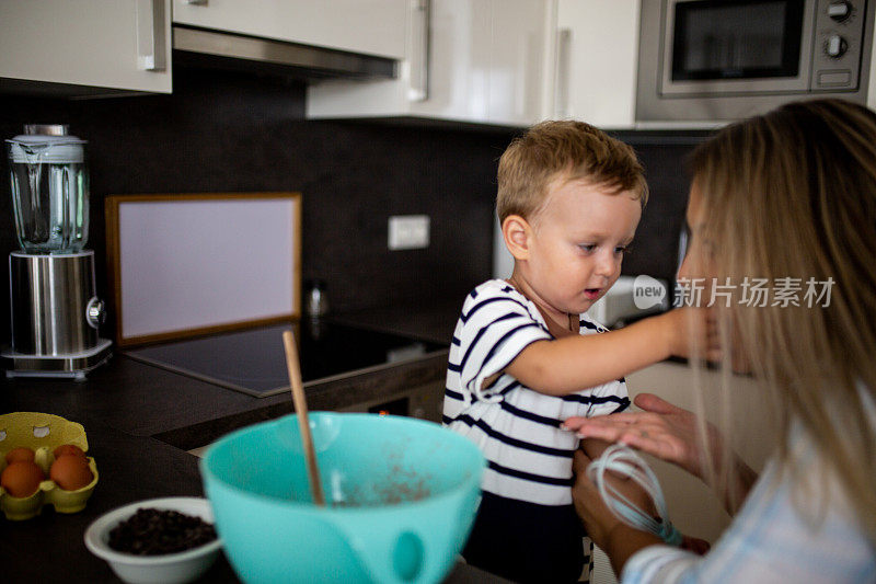 年轻漂亮的母亲和她的小儿子一起烤饼干