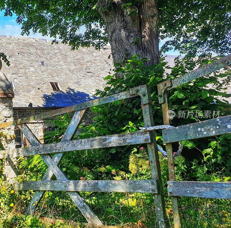 在诺曼底一所房子的入口处有一个带链子的旧木栅栏。