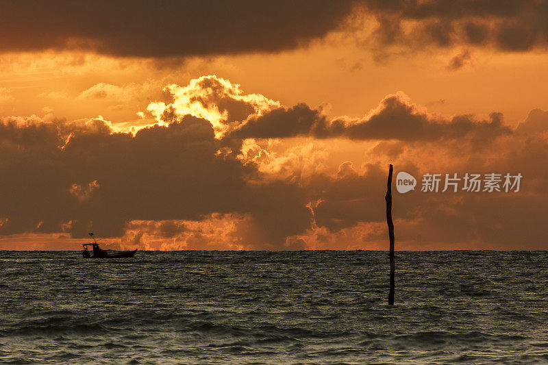 日出时，一艘小渔船在平静的海面上航行，S?o米格尔多斯米拉格雷斯，阿拉戈斯，巴西东北部