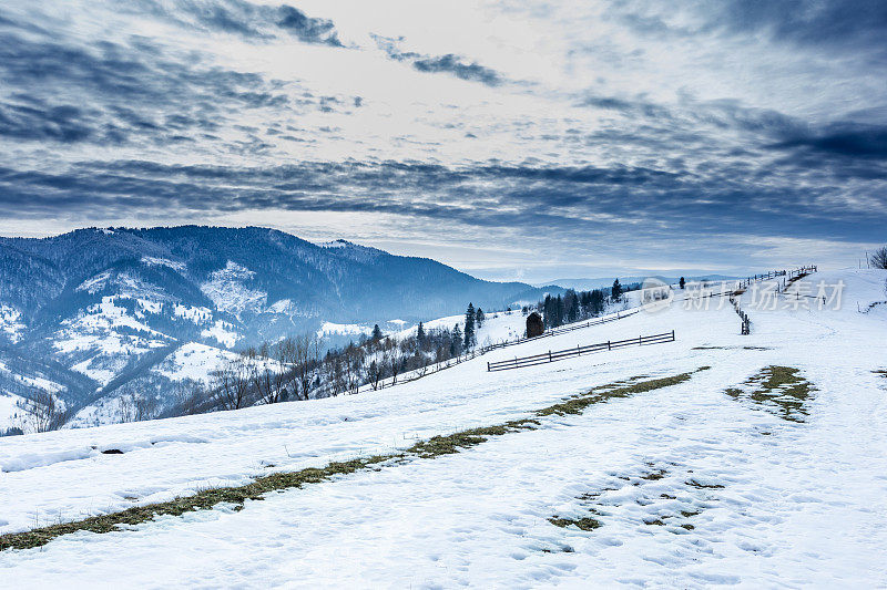 山峰上的雪被风吹走了。冬天的风景。天很冷，下着雪。