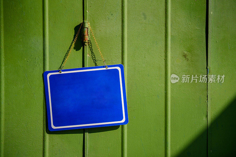 蓝色的布告板挂在彩色的门上
