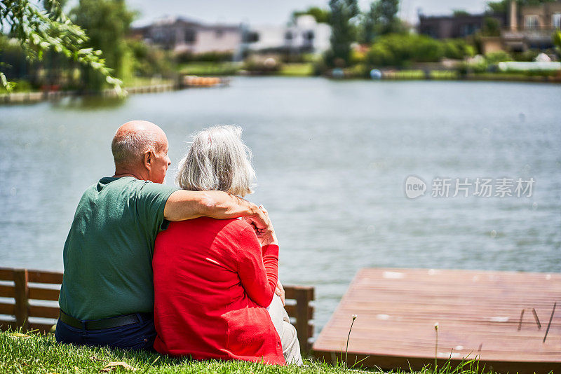 老夫妇手挽着手看湖