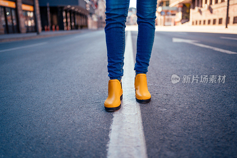 一个女人的脚走在空荡荡的街道上