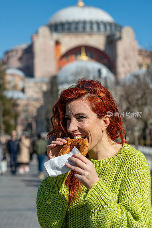 红发女人在圣索菲亚教堂前吃百吉饼