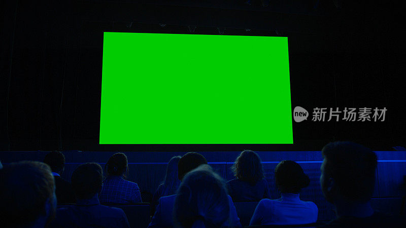 在电影院，观众在绿色屏幕上观看新大片。人们观看视频游戏比赛流媒体，现场音乐会，新产品发布预告片