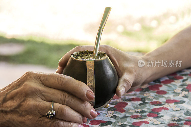 两代人分享“Mate”，一种用“巴拉圭茶”制成的流行饮品。阿根廷，巴西南部，巴拉圭和乌拉圭。