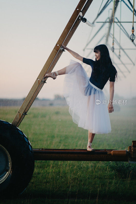 一名芭蕾舞演员以农用喷雾器为背景在田间跳舞。