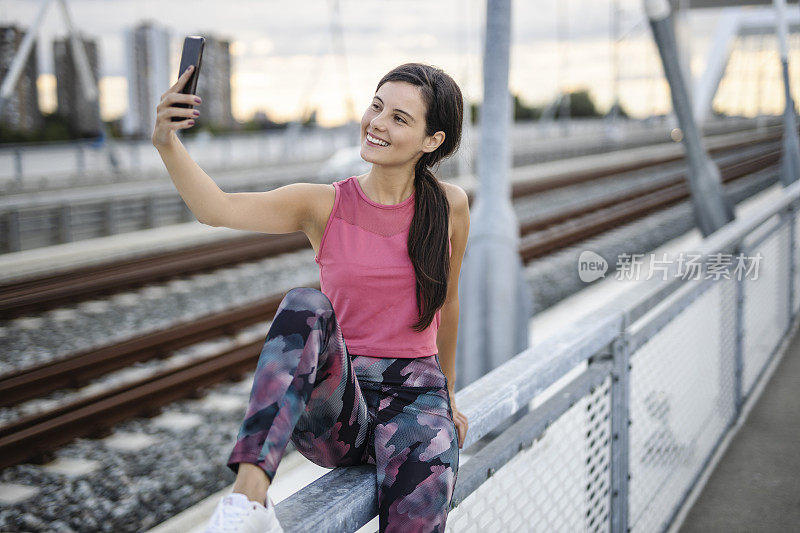 运动女性在户外慢跑后用手机自拍