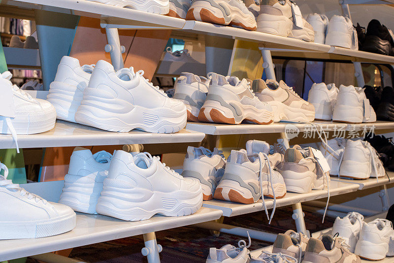 一家卖运动鞋的鞋店货架的侧面视图。在商店里的一些运动鞋的特写图像