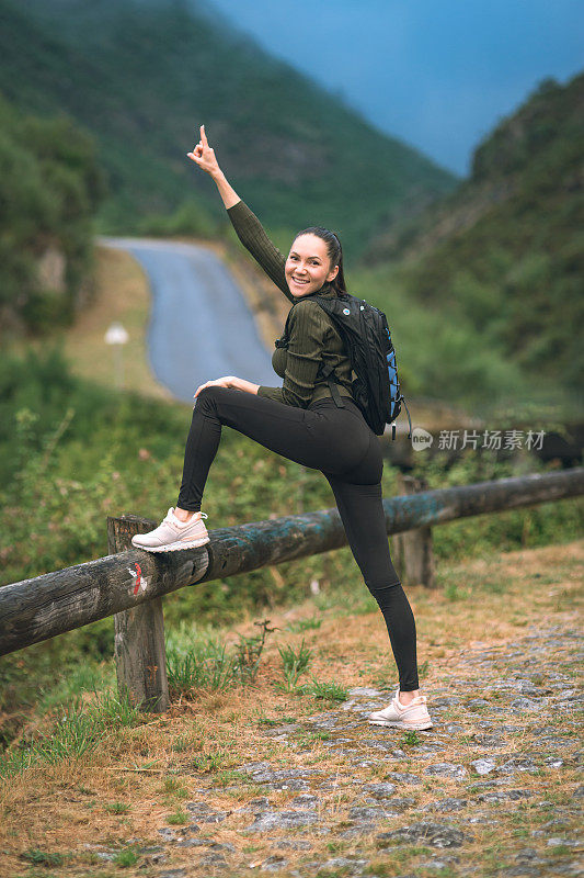 背着背包的年轻女子徒步旅行者在户外的山区旅行