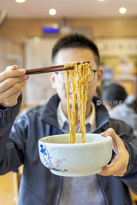 亚洲男子吃蟹黄虾面