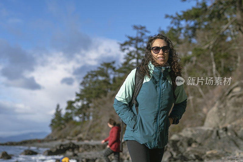 美丽的民族女人在冬天走在海滩上