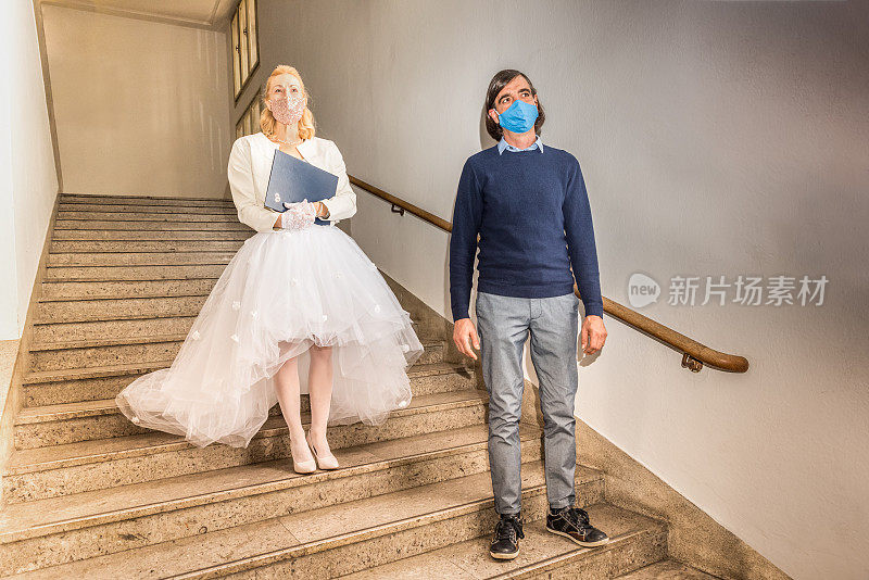 刚结婚-新郎和新娘戴着防护口罩出席在法院走廊举行的婚礼