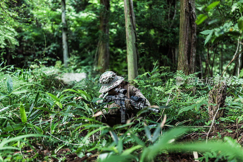 女兵在丛林中用M4卡宾枪保持低姿态