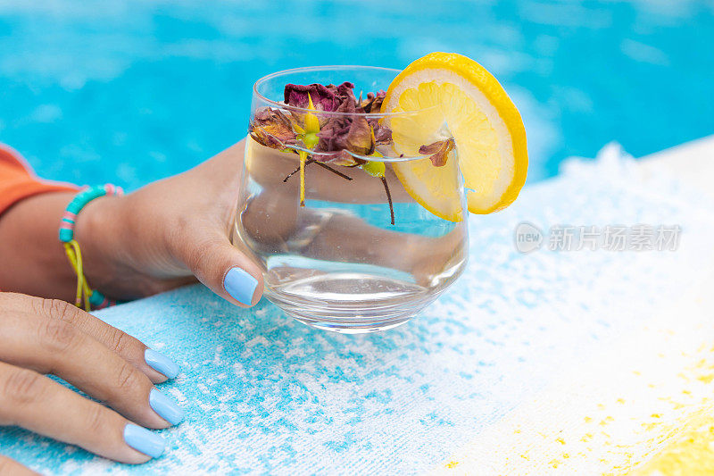 在泳池边喝着水，在户外玩。夏季和生活方式的概念