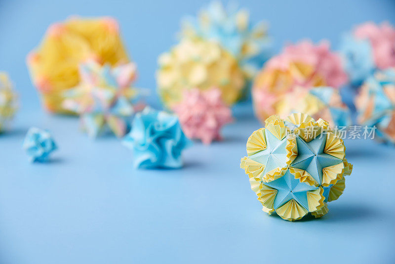 Set的multicolorÂ手工制作modularÂ折纸球或Kusudama孤立在蓝色背景。视觉艺术，几何学，折纸艺术，纸工艺品。特写，选择性聚焦，复制空间。