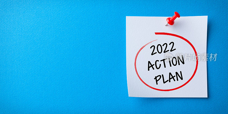 白色便利贴与新的2022年行动计划和红色图钉在蓝色背景
