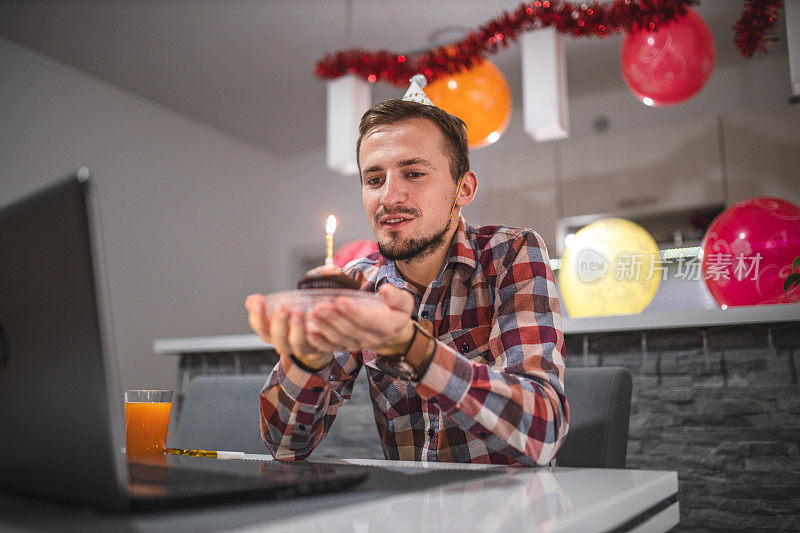 一名年轻人在COVID-19冠状病毒大流行期间与朋友视频通话庆祝生日