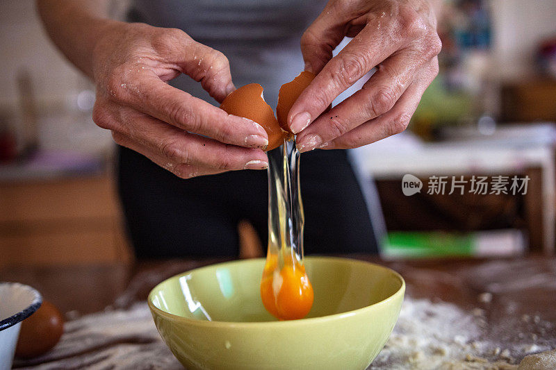 一个女人敲鸡蛋的特写镜头