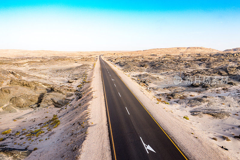 道路通过岩石沙漠前景地平线，纳米比亚