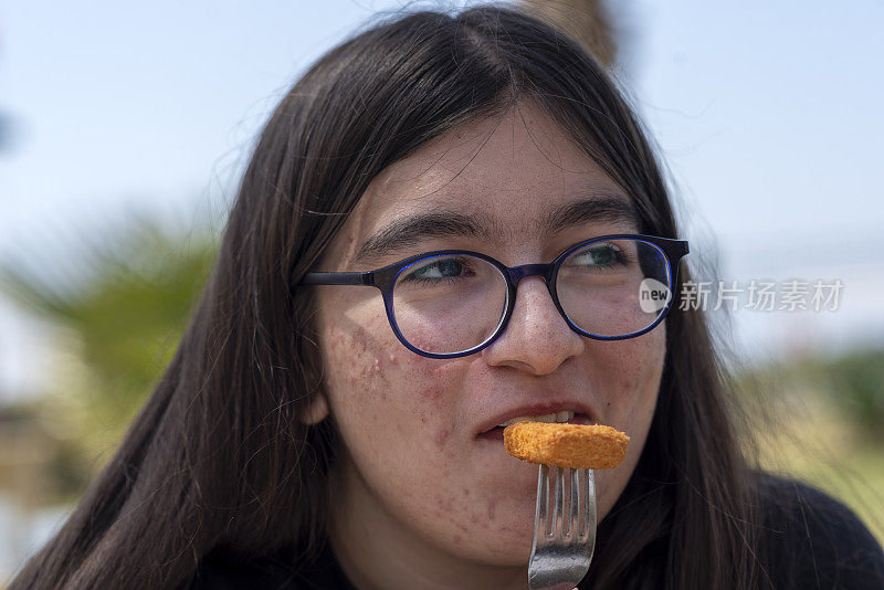 戴眼镜长痘痘的少女吃爆米花鸡