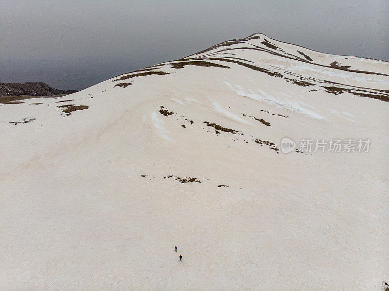 成功的登山队在冬季的高海拔雪山山顶的山脊上连续攀登