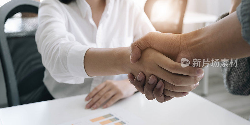 一幅特写照片，一个企业在办公室握手在一个商业合作协议。合作理念业务和成功