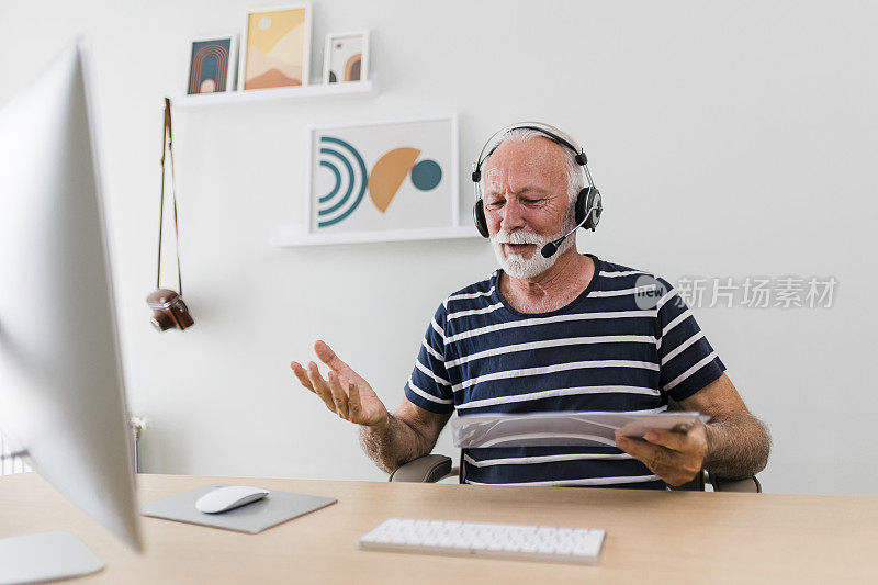 一个老人在呼叫中心工作时使用电脑的镜头