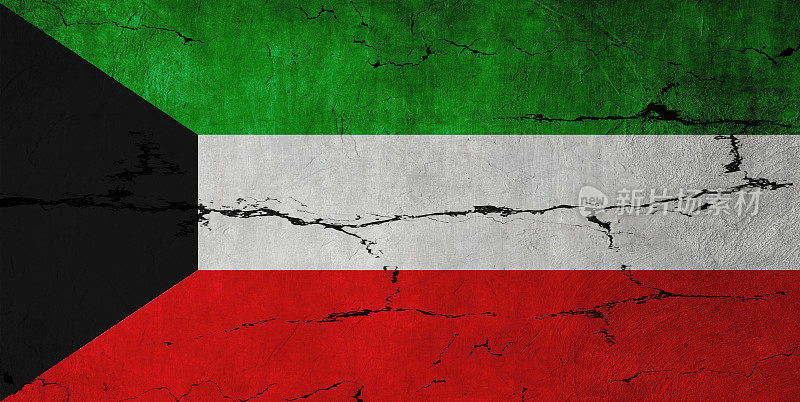 碎裂的墙上挂着科威特国旗